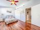 Bright bedroom with hardwood floors, a ceiling fan, and a double-door closet at 16819 Stanza Ct, Tampa, FL 33624