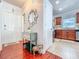Inviting entryway with hardwood floors, decorative mirror and a glimpse into the kitchen at 16819 Stanza Ct, Tampa, FL 33624