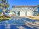 Daytime view of a two-story home with a two-car garage and a spacious driveway at 16819 Stanza Ct, Tampa, FL 33624