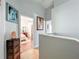 Bright hallway showcasing artwork and leading to a bedroom with hardwood floors and neutral decor at 16819 Stanza Ct, Tampa, FL 33624