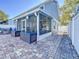 A screened patio featuring brick pavers, two deck boxes, and view to the backyard at 16819 Stanza Ct, Tampa, FL 33624
