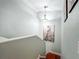 Upstairs view of the staircase highlighting the neutral wall paint and artwork at 16819 Stanza Ct, Tampa, FL 33624