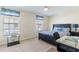 Cozy bedroom with two large windows, dark bed frame and functional workstation at 1728 Mill Run Cir, Tampa, FL 33613