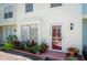 Close-up of a townhouse front door showcasing a lovely landscaped entrance with a red door and flowerpots at 1728 Mill Run Cir, Tampa, FL 33613