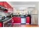 Stylish kitchen featuring red cabinets, stainless steel appliances, and modern countertops at 1728 Mill Run Cir, Tampa, FL 33613