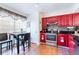 Eat-in kitchen featuring bold red cabinets, stainless steel appliances, and a cozy dining area at 1728 Mill Run Cir, Tampa, FL 33613
