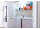 Convenient laundry room featuring a washer, dryer, and storage shelving at 1728 Mill Run Cir, Tampa, FL 33613