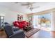 Cozy living room with a bright red sofa, ceiling fan, and sliding glass doors to the patio at 1728 Mill Run Cir, Tampa, FL 33613