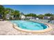Community pool with brick trim, metal ladders, and tennis court in background at 1728 Mill Run Cir, Tampa, FL 33613