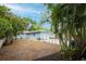 Tropical landscaping, blue home and trash container can be seen in the backyard at 1736 23Rd N Ave, St Petersburg, FL 33710