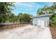 Concrete backyard features tropical landscaping and a blue home at 1736 23Rd N Ave, St Petersburg, FL 33710