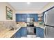 Well-lit kitchen featuring blue cabinets, stainless steel appliances, and granite countertops at 1736 23Rd N Ave, St Petersburg, FL 33710