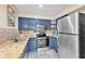 Modern kitchen featuring blue cabinetry, stainless steel appliances, and stone countertops at 1736 23Rd N Ave, St Petersburg, FL 33710