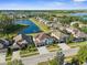 Aerial view of homes in community with pond, lake and lush landscaping at 17917 Machair Ln, Land O Lakes, FL 34638