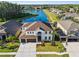 An impressive aerial view of a two-story home overlooking a scenic lake and neighborhood at 17917 Machair Ln, Land O Lakes, FL 34638
