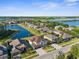 Aerial view of homes in community with pond, lake and lush landscaping at 17917 Machair Ln, Land O Lakes, FL 34638