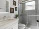 Modern bathroom features a glass-enclosed shower with gray tiles, white vanity, and a framed mirror at 17917 Machair Ln, Land O Lakes, FL 34638