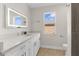 Modern bathroom featuring a lighted mirror, white vanity, and window offering natural light at 17917 Machair Ln, Land O Lakes, FL 34638