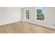 Bright bedroom with beautiful hardwood floors and large windows showcasing the lush greenery outside at 17917 Machair Ln, Land O Lakes, FL 34638