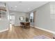 Modern dining room features wood floors, a dining table with seating, and a view of the staircase at 17917 Machair Ln, Land O Lakes, FL 34638