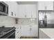 Contemporary kitchen featuring white cabinets, marble backsplash, and stainless steel appliances at 17917 Machair Ln, Land O Lakes, FL 34638