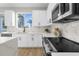 Modern kitchen featuring white cabinets, marble backsplash, stainless steel appliances and a view to the yard at 17917 Machair Ln, Land O Lakes, FL 34638