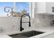 Close-up of a kitchen sink, counter, faucet and a word decoration near the window at 17917 Machair Ln, Land O Lakes, FL 34638