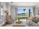 Inviting living room with a plush sofa, accent chair, and serene lake views at 17917 Machair Ln, Land O Lakes, FL 34638