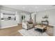 Bright, open living room featuring wood floors, a neutral sofa, and a view into the modern kitchen at 17917 Machair Ln, Land O Lakes, FL 34638
