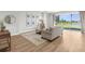 Open living area with a comfortable sofa, wood flooring, and a sliding glass door with a water view at 17917 Machair Ln, Land O Lakes, FL 34638