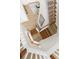 Aerial view of an elegant staircase with wooden steps and white railings leading to the living room at 17917 Machair Ln, Land O Lakes, FL 34638