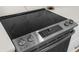 Close-up of a stainless steel stove top with touch controls and white cabinets at 17917 Machair Ln, Land O Lakes, FL 34638