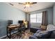 Inviting bedroom featuring a blue accent wall, wood floors, ceiling fan, desk, and comfortable seating at 1821 Bough Ave # 4, Clearwater, FL 33760
