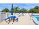 Community pool deck featuring tables with umbrellas providing a comfortable and shaded outdoor area for residents at 1821 Bough Ave # 4, Clearwater, FL 33760