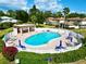 Community pool surrounded by lush landscaping, patio seating, and a covered cabana area at 1821 Bough Ave # 4, Clearwater, FL 33760