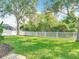 Large, private backyard features a white fence, mature trees, and lush green lawn at 2256 Pantucket Dr, Wesley Chapel, FL 33543