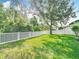 Spacious backyard featuring a well-maintained lawn, mature trees, and a white vinyl fence at 2256 Pantucket Dr, Wesley Chapel, FL 33543