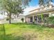 Expansive backyard with a green lawn, mature tree, screened-in porch, and white privacy fence at 2256 Pantucket Dr, Wesley Chapel, FL 33543