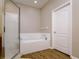 Bathroom featuring soaking tub, glass enclosed shower, and hardwood floors at 2256 Pantucket Dr, Wesley Chapel, FL 33543