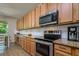 Well-lit kitchen featuring stainless steel appliances, a granite countertop, and wood cabinets at 2256 Pantucket Dr, Wesley Chapel, FL 33543