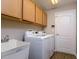 Laundry room with front loading washer and dryer, sink and wooden cabinets at 2256 Pantucket Dr, Wesley Chapel, FL 33543