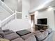 Spacious living room with a stairway, a large sectional, and a modern media console at 2256 Pantucket Dr, Wesley Chapel, FL 33543
