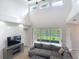 Bright living room featuring tall ceilings, sliding glass doors to the lanai, and a media console at 2256 Pantucket Dr, Wesley Chapel, FL 33543
