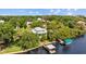 Aerial view of the waterfront home featuring a private dock, boat lift, and lush green surroundings at 2314 N Riverside Dr, Tampa, FL 33602