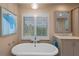 Bright bathroom features a soaking tub and window with shutters at 2314 N Riverside Dr, Tampa, FL 33602