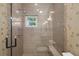 Luxurious walk-in shower with glass enclosure and natural light from a window at 2314 N Riverside Dr, Tampa, FL 33602
