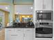 Kitchen area featuring white cabinetry, black countertop, and stainless steel appliances at 2314 N Riverside Dr, Tampa, FL 33602
