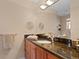 Bright bathroom featuring granite countertops, wood cabinets, and a large mirror at 2421 Brevard Ne Rd, St Petersburg, FL 33704