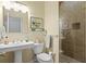 Bathroom showcasing pedestal sink, toilet and tiled walk-in shower with a glass door at 2421 Brevard Ne Rd, St Petersburg, FL 33704