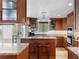 Well-lit kitchen features granite countertops, wood cabinetry, and stainless steel appliances at 2421 Brevard Ne Rd, St Petersburg, FL 33704